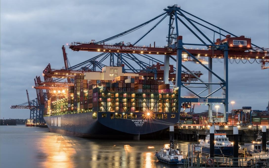 Container ship being loaded at a port terminal at dusk
