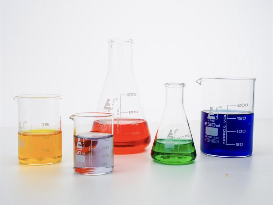 Light oil cut samples of varying colors in laboratory beakers
