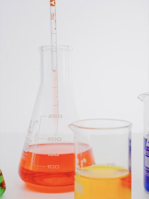 Amber recycled base oil sample in a laboratory flask